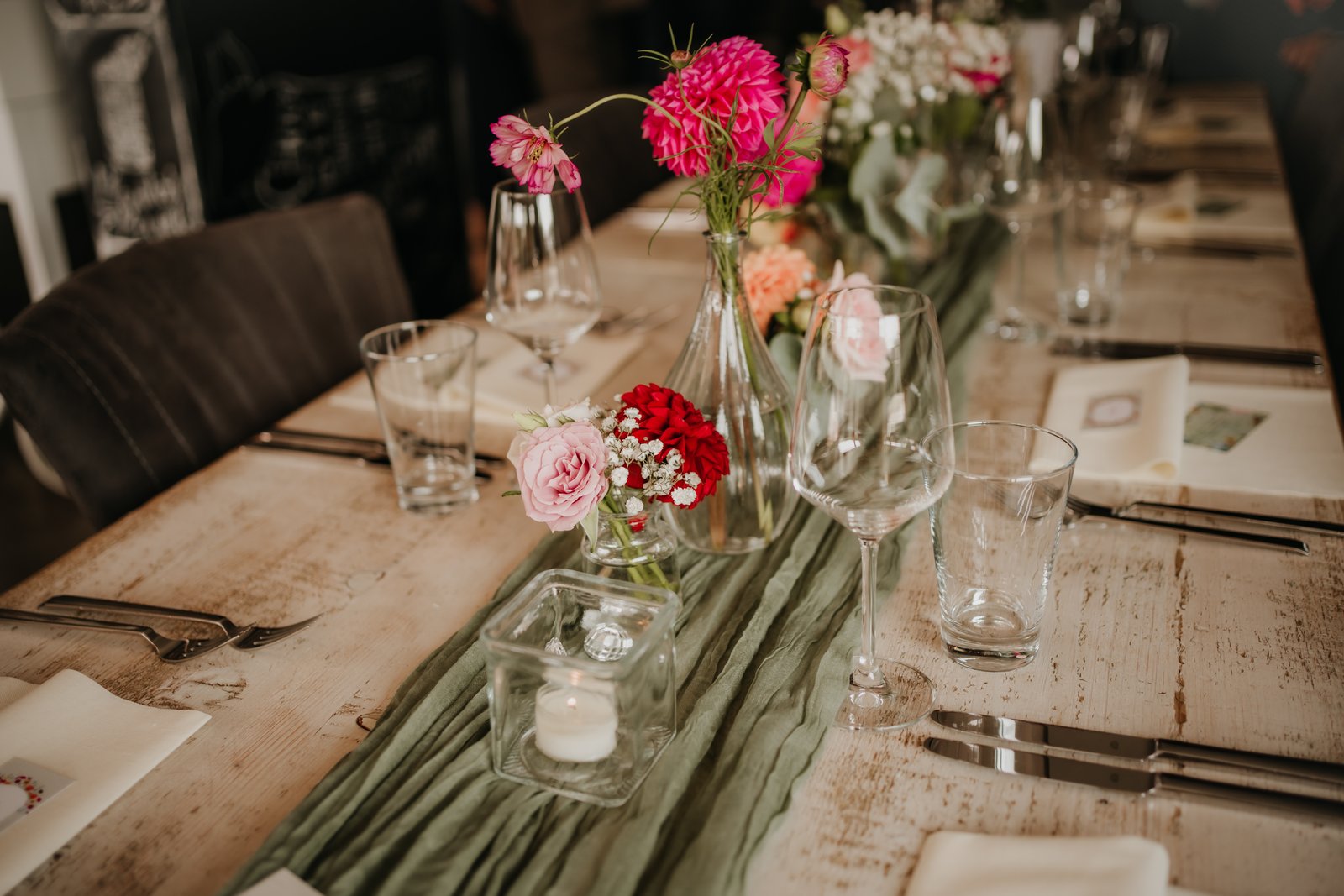 Liebevoll gedeckter Hochzeitstisch mit Blumen, Kerzenlicht und ruhiger, persönlicher Atmosphäre