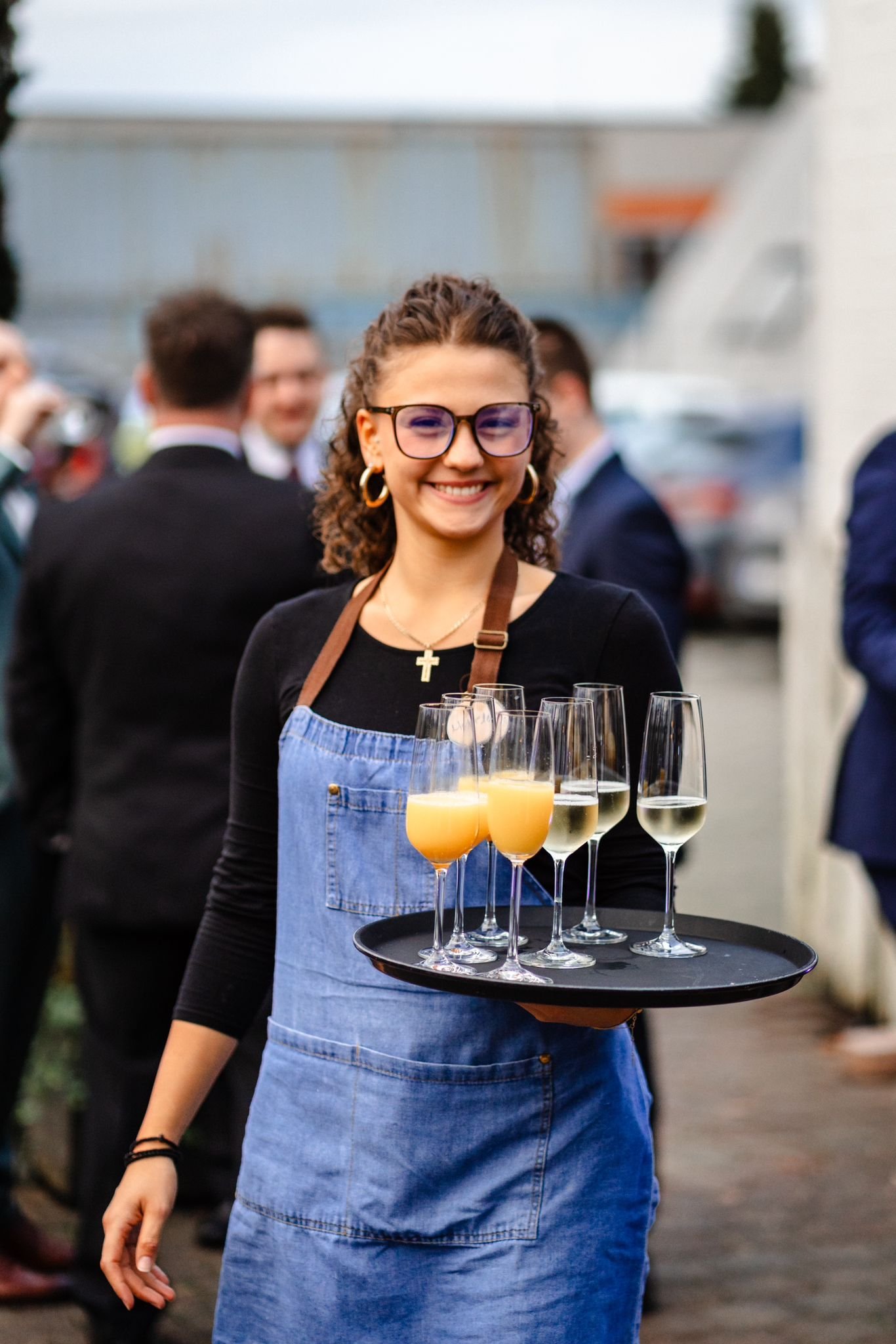 Servicekraft serviert mit freundlicher Ausstrahlung Getränke auf einer Hochzeit